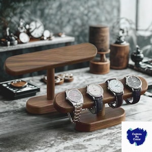 Puede incluir: Expositores de madera para relojes con cuatro relojes de pulsera. Los expositores son de madera oscura y tienen una parte superior curvada. Los relojes tienen correas plateadas y negras. El fondo incluye relojes y otros objetos decorativos.