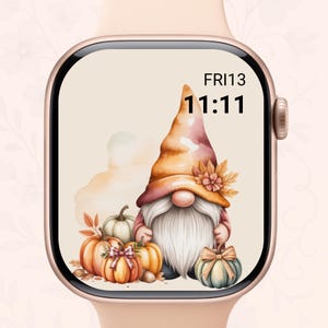May include: A smartwatch with a fall-themed watch face. The face features a watercolor illustration of a gnome with a long white beard, wearing a pointed hat, and surrounded by pumpkins. The time is displayed as 11:11 on Friday the 13th.