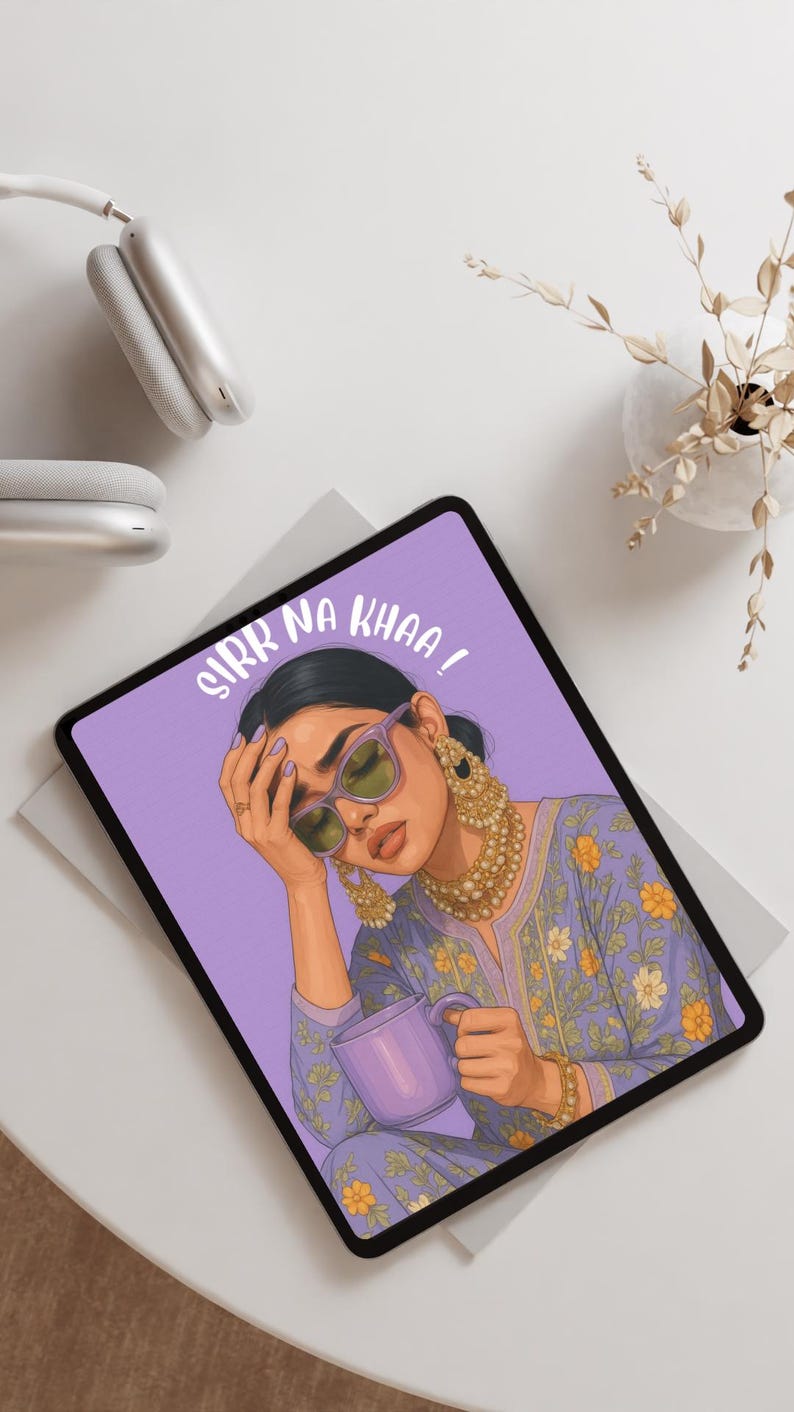 May include: Tablet with a purple screen displaying an illustration of a woman wearing sunglasses and holding a mug. The text "SIRR NA KHAA!" is written on the screen. Gold jewelry and a floral patterned top are also visible.