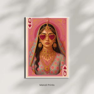 May include: A playing card print featuring the Queen of Hearts. The artwork depicts a woman wearing heart-shaped sunglasses, traditional Indian jewelry, and a floral patterned dress. The card is framed in pink and gold, with the text "Manzil Prints" at the bottom.