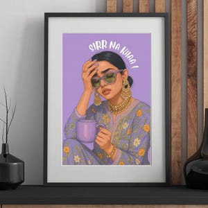 May include: Framed art print featuring a woman with sunglasses and gold jewelry, holding a purple mug. The artwork is set against a lavender background and includes the text "SIRR NA KHAA!". The woman wears a lavender floral print outfit.