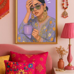 May include: A framed art print with the text "SIRR NA KHAA!". The artwork depicts a woman wearing sunglasses and holding a mug. The room features pink pillows, a lamp, and decorative items.