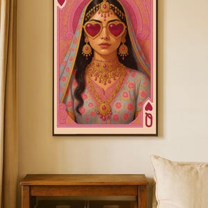 May include: A framed art print featuring a woman adorned in traditional Indian attire, including a headpiece, jewelry, and heart-shaped sunglasses. The artwork is set against a pink and blue backdrop, with the Queen of Hearts card symbols.
