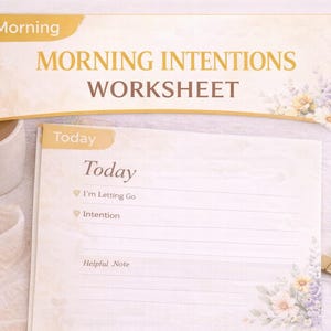 May include: A morning intentions worksheet with the text "Morning Intentions Worksheet" and "Today". The worksheet has floral accents and is accompanied by a pen, a gold paper clip, and two white ceramic mugs with a beverage.