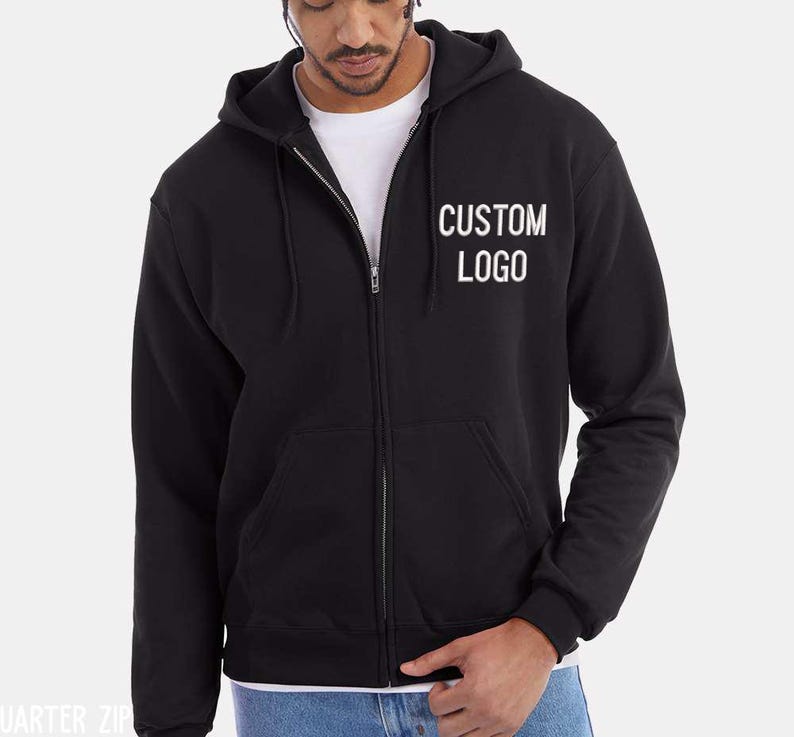 A man wearing a black hooded sweatshirt with the text "CUSTOM LOGO" printed on it.