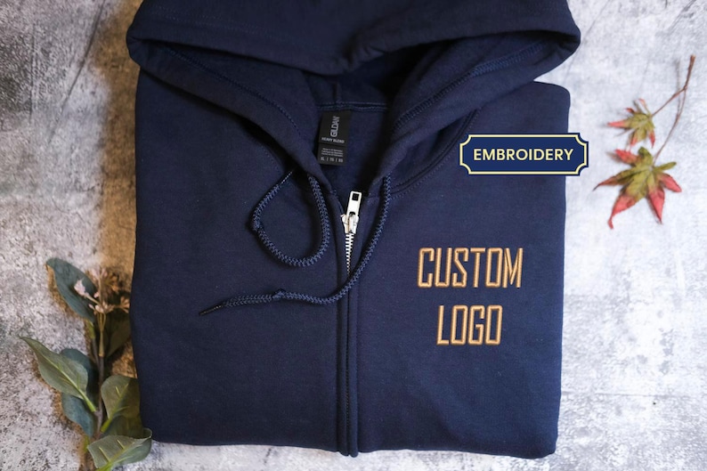 A navy blue hoodie with the text "CUSTOM LOGO" printed on it, along with a zipper and drawstring.