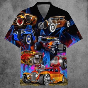 May include: Short-sleeved button-down shirt featuring a vibrant design of classic hot rod cars in various colors, set against a backdrop of blue and red flames. The shirt has a black collar and a gray interior.