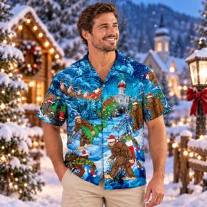 May include: A short-sleeve button-down shirt featuring a vibrant blue winter scene with multiple brown Bigfoot figures wearing Santa hats. The print includes snowy pine trees, a domed building, and Bigfoot carrying Christmas trees and stockings.