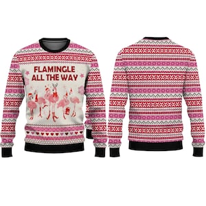 May include: A long-sleeve crewneck sweater featuring a cream-colored front with pink flamingos wearing Santa hats and the text FLAMINGLE ALL THE WAY. The design includes red and pink geometric patterns, hearts, and snowflakes.