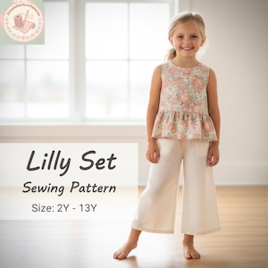 Peut inclure: Une jeune fille porte un haut à imprimé floral et un pantalon blanc. Le haut a un ourlet à volants. Le texte "Lilly Set Sewing Pattern" est affiché, avec les tailles 2Y - 13Y. L'image est dans une pièce lumineuse.