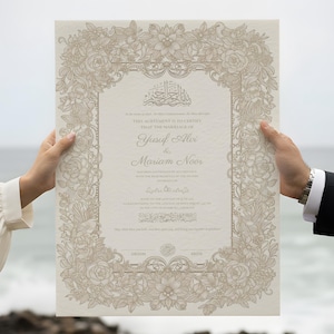 Op de afbeelding: Een beige huwelijkscertificaat met een sierlijke bloemenrand wordt getoond. Het document bevat Arabische tekst en de namen Yusuf Ali en Mariam Noor. De achtergrond toont een wazig uitzicht op de zee en de lucht.