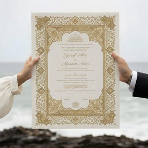 Op de afbeelding: Een decoratief huwelijkscertificaat met gouden filigraan en tekst. Het document wordt door twee personen omhoog gehouden, met de oceaan op de achtergrond. Het certificaat bevat de namen Yusuf Alvi en Mariam Noor.