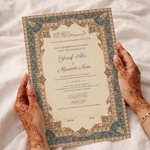 Puede incluir: Un certificado de matrimonio con bordes azules y dorados ornamentados es sostenido. El documento presenta escritura árabe y los nombres Yusuf Alvi y Mariam Noor. El certificado es para un matrimonio.