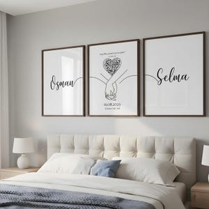 Può includere: Tre stampe artistiche incorniciate con cornici marrone scuro. Le stampe presentano i nomi "Osman" e "Selma" in elegante scrittura, e una stampa centrale con un design a forma di cuore e il testo "And We created you in pairs".