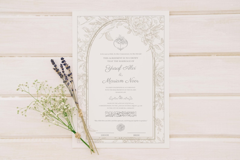 May include: A wedding certificate with floral border and the names Yusuf Alvi & Mariam Noor. The certificate is on a white wooden surface, with sprigs of lavender and baby's breath.