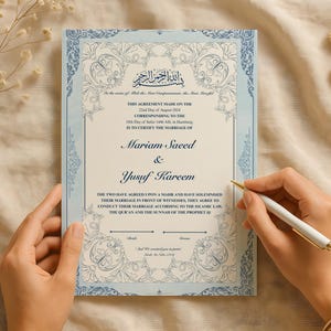 May include: A light blue and white wedding certificate with floral patterns and Arabic script. The names "Mariam Saeed" and "Yusuf Kareem" are displayed. A hand holds a pen, ready to sign the document, which is in cm.