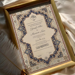 Op de afbeelding: Een ingelijste huwelijksakte met sierlijke bloemen- en geometrische patronen in blauw, crème en rood. De gouden lijst omringt het document, met de namen Yusuf Alvi en Mariam Noor. Een ganzenveer ligt in de buurt van het frame.