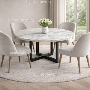 May include: A round marble dining table with a black metal base is surrounded by four light gray upholstered chairs. The table is set on a round, light gray rug. A vase of white flowers sits on the table.