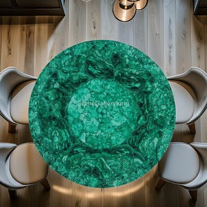 May include: Overhead view of a round, green malachite table with a swirling pattern. Four white and beige chairs surround the table, set on a light wood floor. The text "StoneGalleryking" is visible on the table.