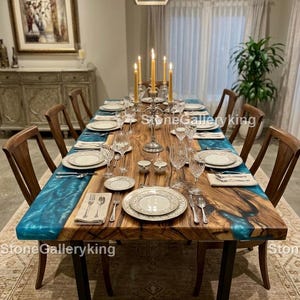 Könnte beinhalten: Ein großer Esstisch aus Holz mit einem blauen Epoxidharz-Fluss-Design, gedeckt für ein formelles Abendessen. Der Tisch ist von Holzstühlen umgeben und mit feinem Porzellan, Silberbesteck und Kristallgläsern gedeckt. Ein Leuchter mit brennenden Kerzen steht in der Mitte.