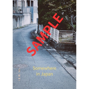 以下が含まれることがあります： 日本のある通りの風景。曲がりくねった道、建物、緑豊かな木々が写っています。画像にはヴィンテージ感があり、赤色の「SAMPLE」という文字が重ねられています。下部には「Somewhere in Japan」と書かれています。