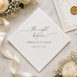 May include: A square white paper napkin featuring dark green text that reads the night before, followed by the names AMELIA and JACK separated by a heart symbol, and the date JUNE 05, 2026. The napkin has a textured border and a smooth centre.