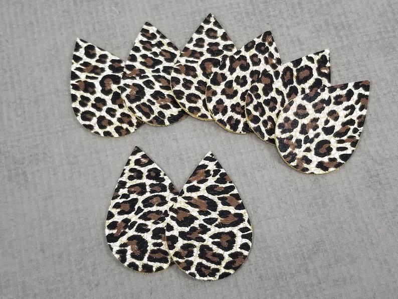 May include: Eight brown and gold leopard print teardrop-shaped leather earring blanks.