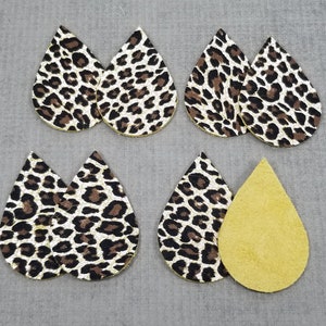 May include: Six teardrop-shaped leather earrings, five with a leopard print pattern in brown, black, and white, and one solid yellow.
