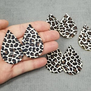 May include: Five pairs of teardrop-shaped earrings with a black and white leopard print pattern.