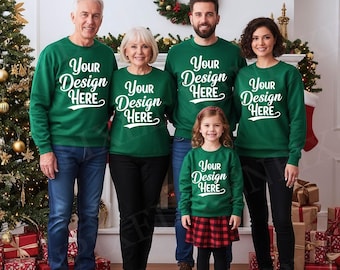 May include: A family of five wearing matching green sweatshirts with the text "Your Design Here" in white. The family is standing in front of a fireplace decorated for Christmas, with a Christmas tree and wrapped gifts visible.
