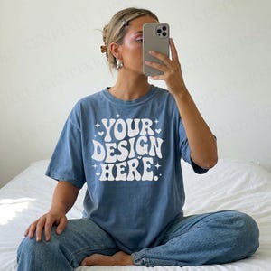 Blue jean Comfort Colors 1717 t-shirt mockup shown in a bright bedroom mirror selfie with oversized unisex fit.