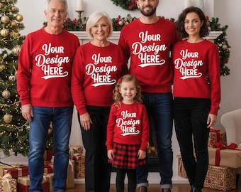 Puede incluir: Una familia de cinco personas con sudaderas rojas a juego con el texto "Your Design Here" en blanco. El grupo está de pie frente a una chimenea decorada para Navidad, con un árbol de Navidad y regalos envueltos visibles.