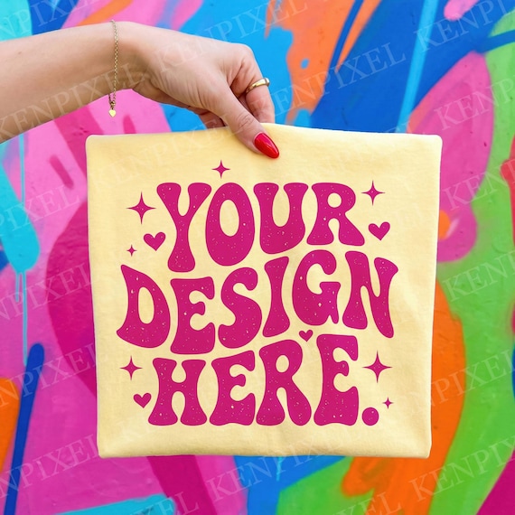 Comfort Colors 1717 Butter Shirt Mockup | Hand Held Folded Tee | Colorful Graffiti Wall | Blank T-Shirt Photo