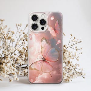 Puede incluir: Funda de tel&eacute;fono transparente con un dise&ntilde;o de mariposa rosa y dorada sobre un fondo nublado. La funda tiene una paleta de colores rosa y azul claro, creando una est&eacute;tica delicada y et&eacute;rea. Flores blancas rodean la funda.