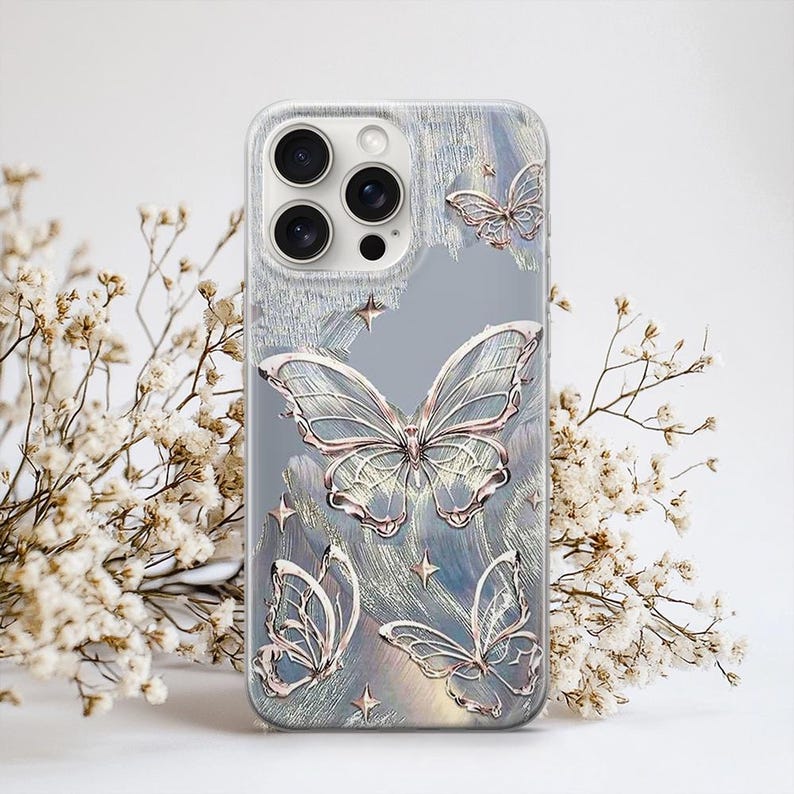Puede incluir: Funda transparente para tel&eacute;fono con dise&ntilde;o de mariposas. La funda presenta m&uacute;ltiples mariposas en color oro rosa met&aacute;lico, sobre un fondo texturizado azul claro y gris. Tambi&eacute;n hay peque&ntilde;os detalles de estrellas.