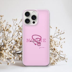Puede incluir: Funda de tel&eacute;fono rosa con un dise&ntilde;o de estetoscopio rosa y la palabra "NURSE". El texto "you can..." est&aacute; debajo del estetoscopio. La funda tiene un borde transparente y un acabado brillante.