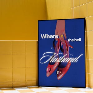 May include: A framed poster with a blue background and the text "Where the hell is my Husband". The image features a hand holding a pair of red high heels. The heels have pink and purple straps.