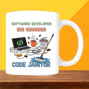 May include: White ceramic mug with a humorous design for software developers. The mug features the text "SOFTWARE DEVELOPER BUG SUMMONER CODE JANITOR" and illustrations of a laptop, coffee cup, and mop.