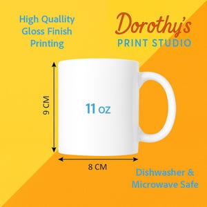 Op de afbeelding: Een witte keramische mok van 11 oz, met een hoogte van 9 cm en een breedte van 8 cm. De mok heeft de tekst "11 oz" en is voorzien van het label "Vaatwasser & Magnetronbestendig". De mok is van Dorothy's Print Studio.