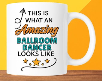 Puede incluir: Taza de cerámica blanca con el texto "THIS IS WHAT AN Amazing BALLROOM DANCER LOOKS LIKE" en negro, naranja y turquesa. La taza tiene un asa curva y está sobre un fondo amarillo y naranja.