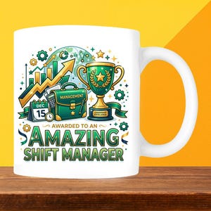 May include: White ceramic mug featuring a colourful graphic. The design includes a green trophy, briefcase, and the words "AWARDED TO AN AMAZING SHIFT MANAGER." The mug has a large white handle and is set against a yellow and brown background.