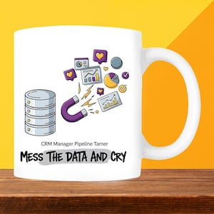 May include: White ceramic mug with a handle, featuring a cartoon design of a database, a magnet, and data charts. The text "MESS THE DATA AND CRY" is below the graphic, with "CRM Manager Pipeline Tamer" above it.