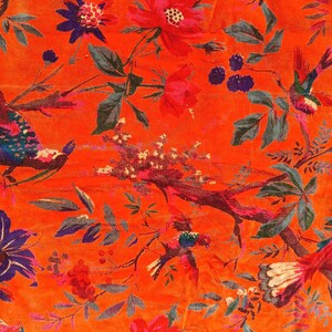 May include: Bright orange fabric with a floral and bird design. The pattern includes red and pink flowers, blue and purple details, and colourful birds on branches. Green leaves and berries complete the botanical theme.