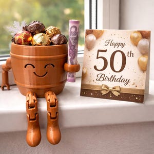 May include: A whimsical brown barrel-shaped container with a smiling face, holding wrapped chocolates and a rolled-up bill. A birthday card with "Happy 50th Birthday" is next to it. The barrel has legs and arms.