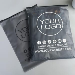 ロゴプリント入りブラックフロストジッパーバッグ、ドレス/水着/パーカー/Tシャツ/ウィッグ用ガーメントバッグパック、ロゴプリント入りブラックジッパーバッグ