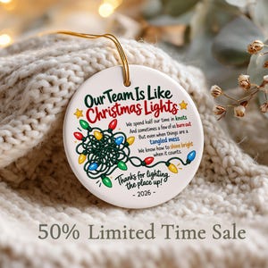 May include: A round white ceramic ornament featuring a colourful illustration of tangled Christmas lights and the text: Our Team Is Like Christmas Lights, We spend half our time in knots, And sometimes a few of us burn out, But even when things are a tangled mess, We know how to shine bright when it counts, Thanks for lighting the place up! - 2026 -