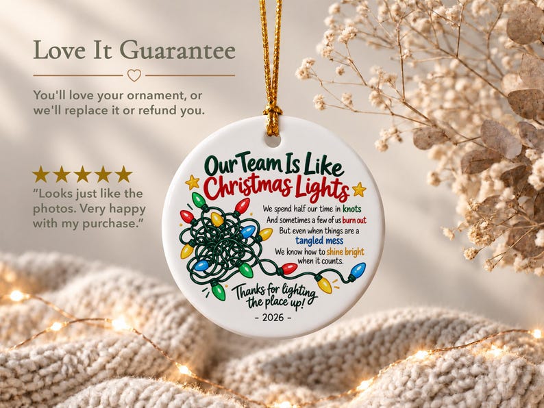 May include: A round white ceramic ornament hanging by a gold cord. It features a graphic of tangled multi-coloured Christmas lights and text that reads: Our Team Is Like Christmas Lights, We spend half our time in knots, And sometimes a few of us burn out, But even when things are a tangled mess, We know how to shine bright when it counts, Thanks for lighting the place up! - 2026 -