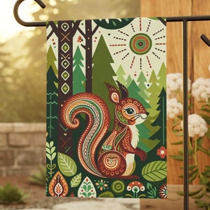 Könnte beinhalten: Eine rechteckige Gartenflagge mit einer stilisierten Eichhörnchen-Illustration mit komplizierten Mustern in Rot-, Orange- und Grüntönen. Das Design zeigt einen Waldhintergrund mit immergrünen Bäumen, einer Sonne und verschiedenen botanischen Elementen.