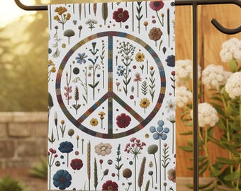 Puede incluir: Una bandera de jardín rectangular con fondo blanco y un símbolo de la paz central compuesto por un patrón texturizado multicolor. El diseño está rodeado por varias pequeñas ilustraciones botánicas coloridas de flores, tallos y hojas.