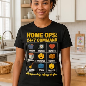 May include: Black t-shirt with the text "HOME OPS: 24/7 COMMAND" and icons representing household tasks. The shirt includes icons for laundry, meals, hearts, schedule, morale, supply, clean, fold, and watch. The text "Always on duty. Always the glue." is also included.